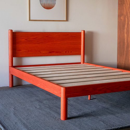 Custom Color modern solid oak designer bed frame Keeps Architect bed with headboard integrated joinery in bright red vermillion with premium birch slats on blue carpet