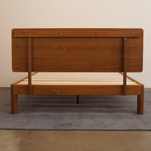 Rear assembly view of Keeps solid oak bed frame and attached wood headboard with bolted joinery in acorn brown finish