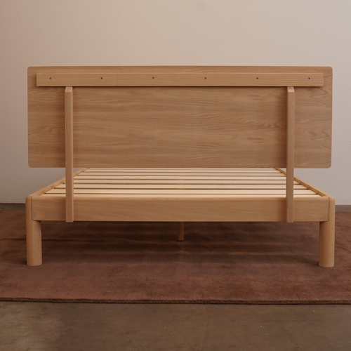 Rear assembly view of Keeps solid oak bed frame and attached wood headboard with bolted joinery in white natural finish