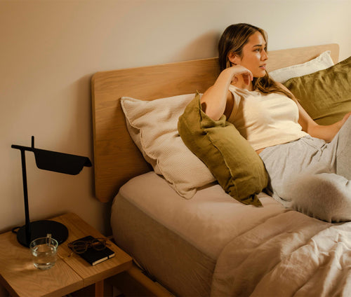 Young Woman on comfortable Keeps easy to assemble strap queen size bed with wall mount headboard and wall mount headboard and nightstand with modern lamp