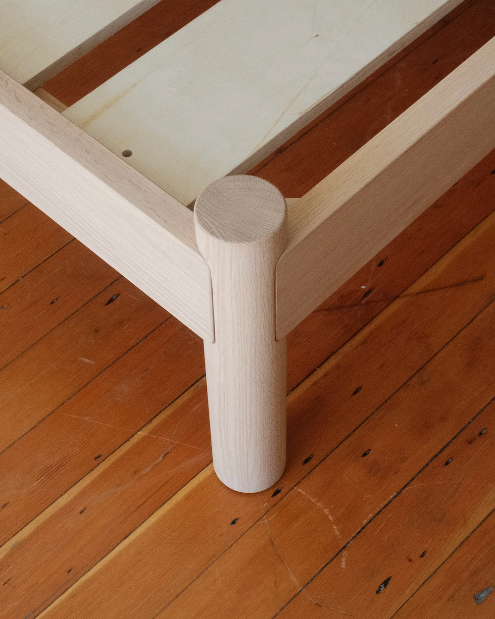 Keeps Architect Bed Frame corner leg joinery in light natural on wood floor