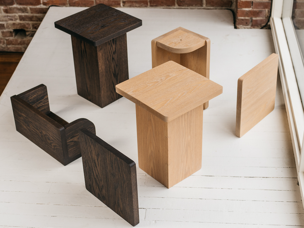 Keeps Home nightstands in natural and smoked finish with easy assembly parts arranged on white wood floor
