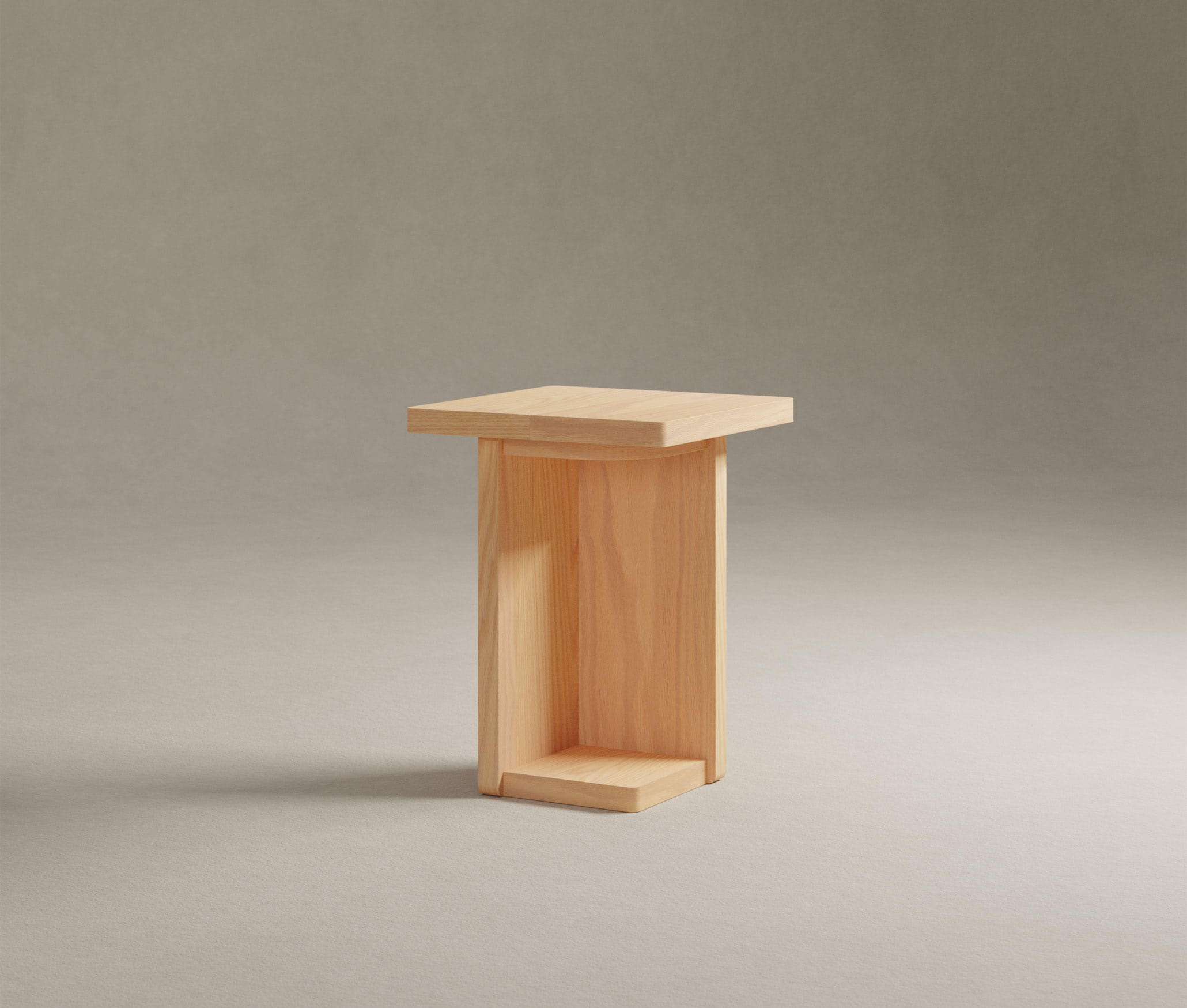 A minimalist wooden stool with a flat top and side panels on a plain background.